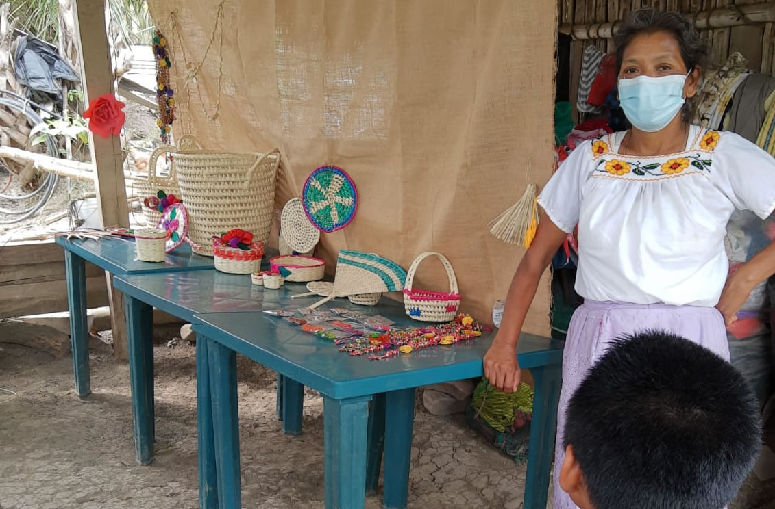 Flaviana, mujer generosa, entre  canastos coloridos y grillos pintados